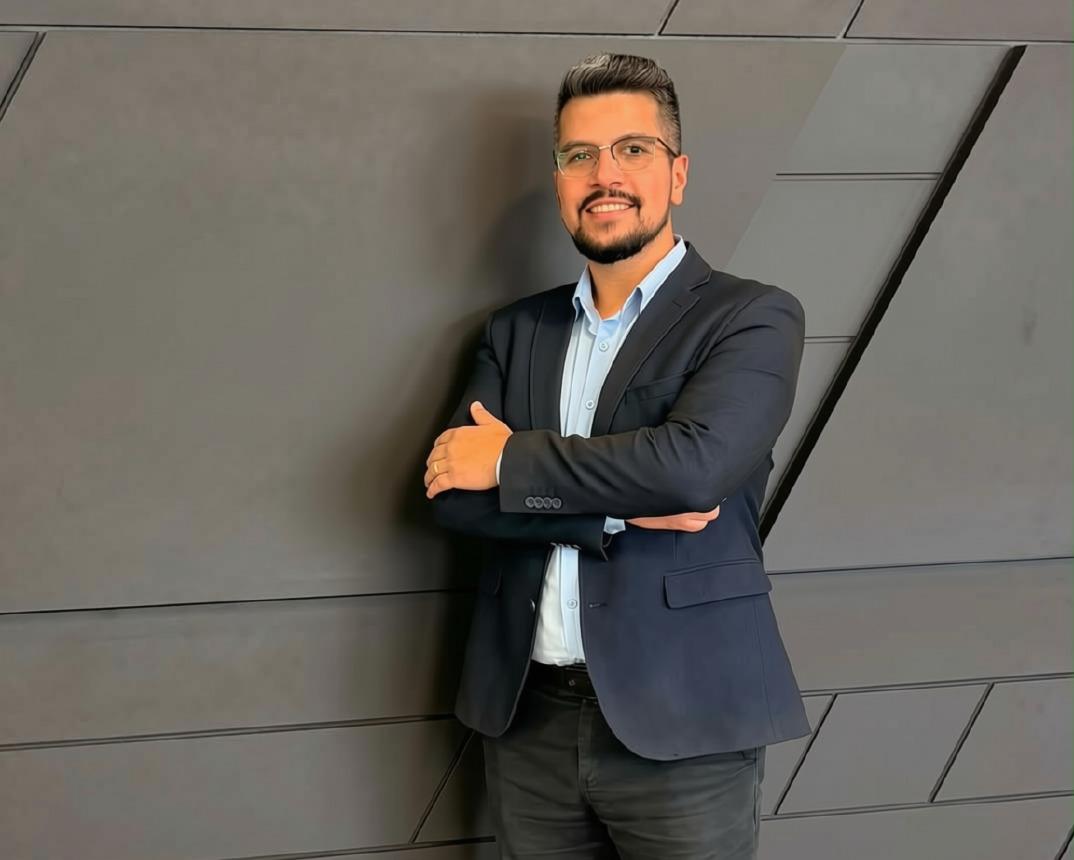 Tiarles Rocha, de óculos e blazer, sorrindo
